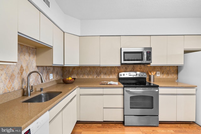5501 Seminary Rd Unit 407S, Falls Church, VA 22041 - kitchen featuring stainless steel appliances, backsplash, light wood-style floors, light countertops, and white cabinetry