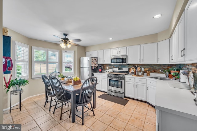 1632 Breakers Dr, Manahawkin, NJ 08050 - kitchen with stainless steel appliances, decorative backsplash, ceiling fan, light tile patterned floors, and white cabinets