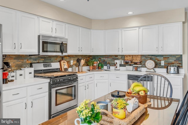 1632 Breakers Dr, Manahawkin, NJ 08050 - kitchen featuring appliances with stainless steel finishes, light countertops, white cabinets, decorative backsplash, and recessed lighting