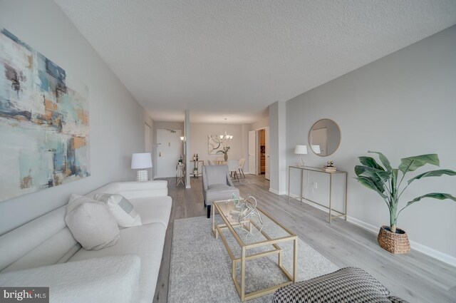 5300 Holmes Run Pkwy Unit 709, Alexandria, VA 22304 - living area with wood finished floors, a textured ceiling, and a chandelier