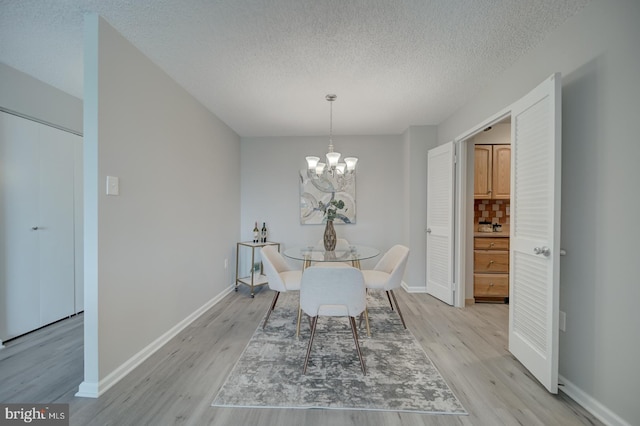 5300 Holmes Run Pkwy Unit 709, Alexandria, VA 22304 - dining room featuring light wood-type flooring, a textured ceiling, and a chandelier