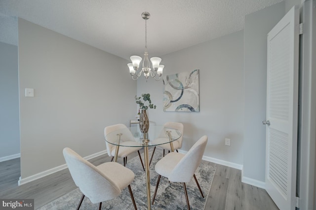 5300 Holmes Run Pkwy Unit 709, Alexandria, VA 22304 - dining area with light wood finished floors, a chandelier, and a textured ceiling
