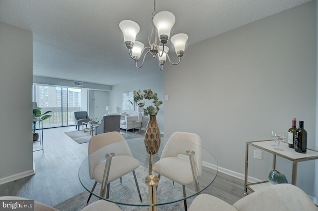 5300 Holmes Run Pkwy Unit 709, Alexandria, VA 22304 - dining area featuring wood finished floors, a chandelier, and a textured ceiling