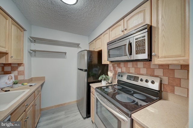 5300 Holmes Run Pkwy Unit 709, Alexandria, VA 22304 - kitchen with stainless steel appliances, light wood-style flooring, light brown cabinetry, a textured ceiling, and light countertops