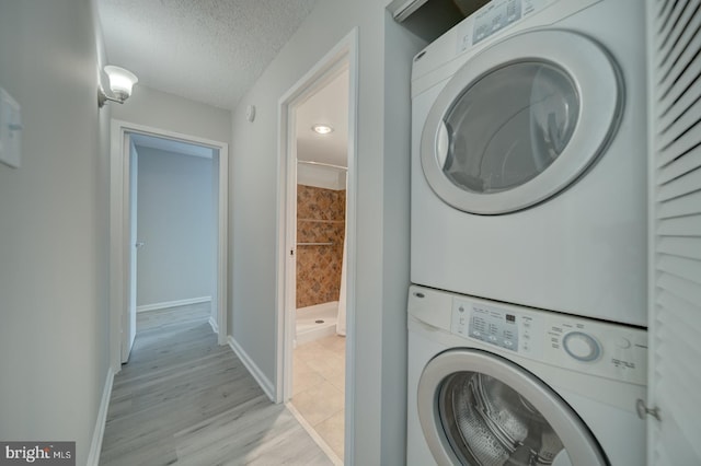 5300 Holmes Run Pkwy Unit 709, Alexandria, VA 22304 - laundry area with stacked washing machine and dryer, a textured ceiling, and light wood finished floors