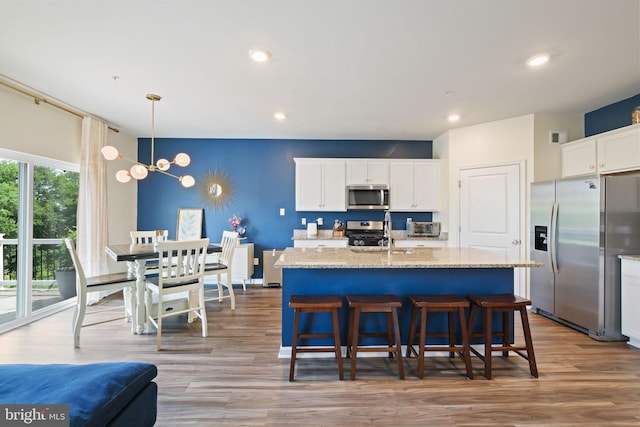 2014 Fauna Dr, Frederick, MD 21702 - kitchen with appliances with stainless steel finishes, wood finished floors, white cabinets, an island with sink, and recessed lighting