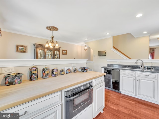 42 Bissenden Way, Reinholds, PA 17569 - kitchen featuring black dishwasher, crown molding, white cabinetry, wall oven, and hanging light fixtures