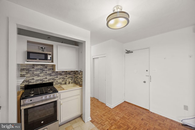 1301 N Harrison St Unit 1106, Wilmington, DE 19806 - kitchen featuring stainless steel appliances, backsplash, light countertops, and white cabinetry