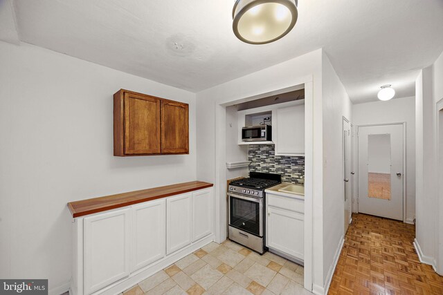1301 N Harrison St Unit 1106, Wilmington, DE 19806 - kitchen featuring stainless steel appliances, backsplash, white cabinets, and light countertops