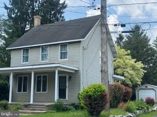 189 Rolling Stone Rd, Kylertown, PA 16847 - view of front of house with covered porch, a chimney, an outdoor structure, and a detached garage