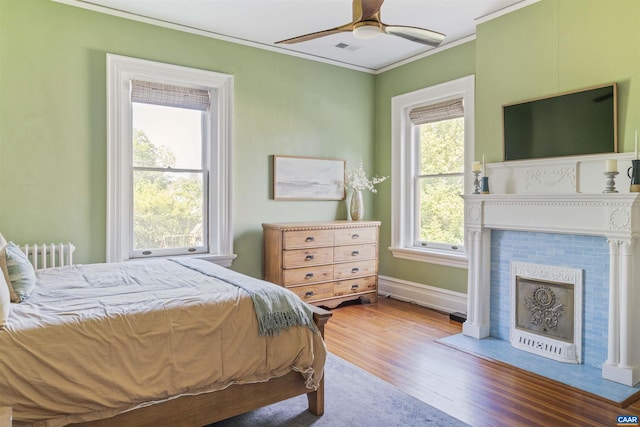 2024 Rivermont Ave, Lynchburg, VA 24503 - bedroom with wood finished floors, crown molding, a tiled fireplace, radiator, and a ceiling fan