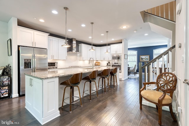 6006 Charles Xing, Ellicott City, MD 21043 - kitchen featuring appliances with stainless steel finishes, wall chimney exhaust hood, backsplash, dark wood-style flooring, and white cabinetry