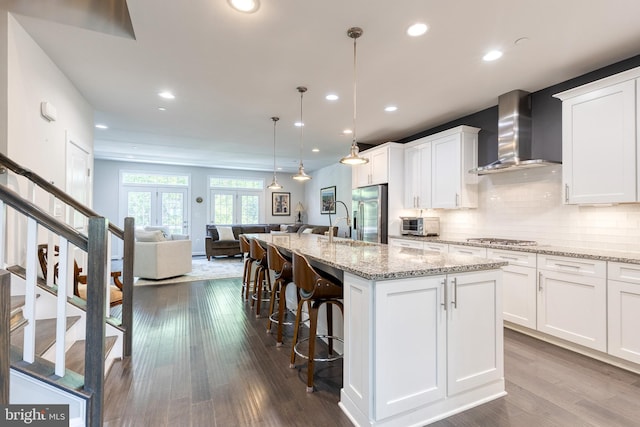 6006 Charles Xing, Ellicott City, MD 21043 - kitchen with wall chimney range hood, open floor plan, white cabinetry, appliances with stainless steel finishes, and recessed lighting
