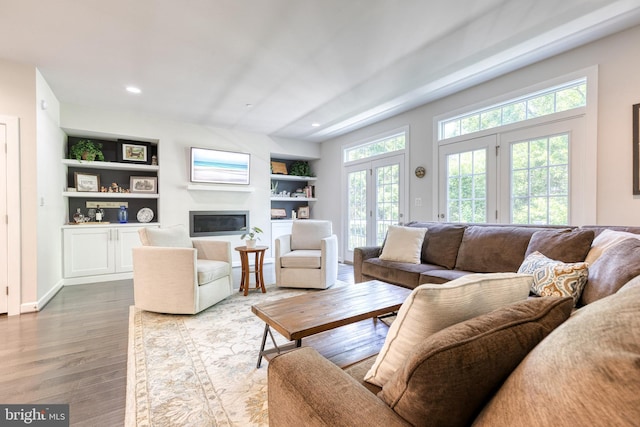 6006 Charles Xing, Ellicott City, MD 21043 - living area featuring wood finished floors, a glass covered fireplace, built in shelves, and recessed lighting