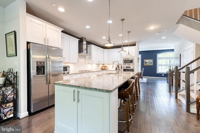 6006 Charles Xing, Ellicott City, MD 21043 - kitchen featuring stainless steel appliances, wall chimney range hood, dark wood-type flooring, white cabinets, and decorative backsplash
