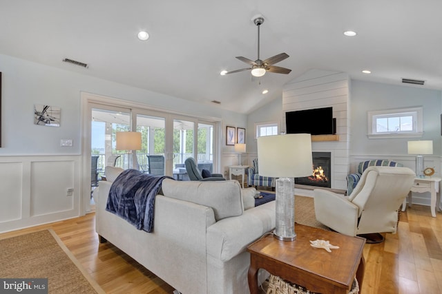1510 N Bay Shore Dr, Milton, DE 19968 - living area featuring a decorative wall, ceiling fan, a wainscoted wall, healthy amount of natural light, and a large fireplace