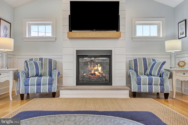 1510 N Bay Shore Dr, Milton, DE 19968 - living area featuring vaulted ceiling, wood finished floors, healthy amount of natural light, a large fireplace, and a decorative wall