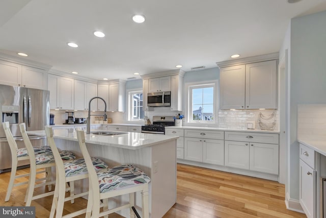 1510 N Bay Shore Dr, Milton, DE 19968 - kitchen with appliances with stainless steel finishes, a kitchen bar, light countertops, backsplash, and recessed lighting