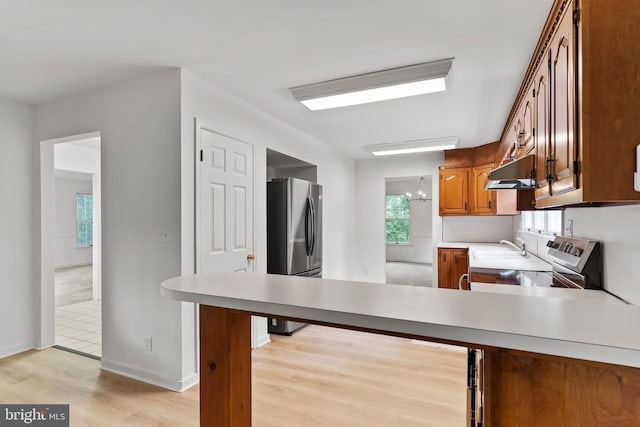 7 Forest Ln, Carlisle, PA 17015 - kitchen featuring under cabinet range hood, stainless steel appliances, brown cabinetry, a peninsula, and light countertops