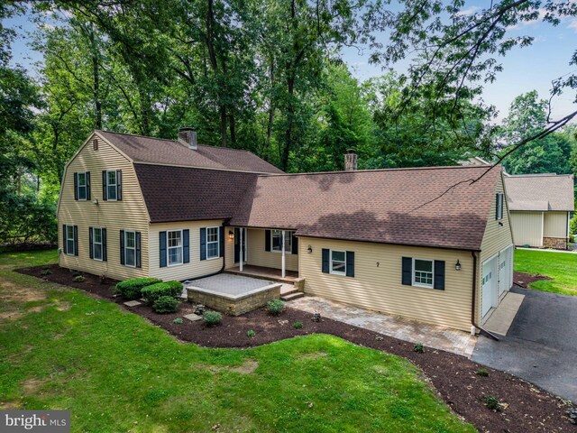 7 Forest Ln, Carlisle, PA 17015 - view of front facade featuring a chimney, driveway, a front yard, a shingled roof, and a garage