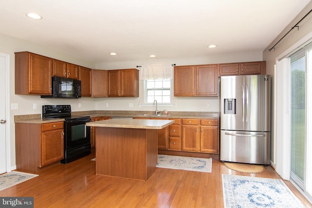 43 Oak Crest Ct, Hanover, PA 17331 - kitchen featuring black appliances, light wood-type flooring, brown cabinetry, a kitchen island, and recessed lighting