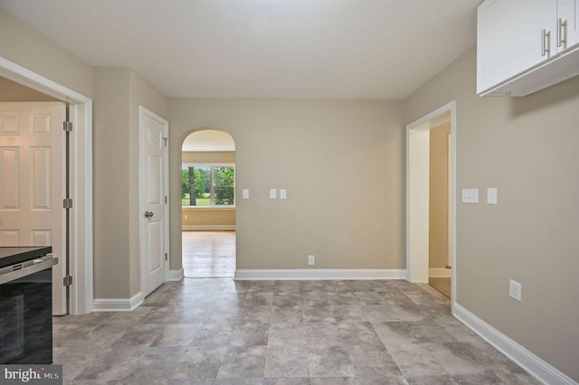 3010 Forrest Ave, Dover, DE 19904 - unfurnished dining area featuring arched walkways and stone finish floors