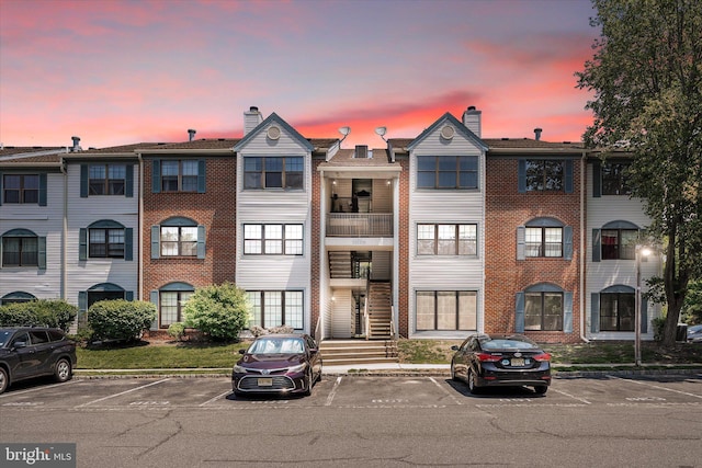 49 Joyner Ct, Lawrence, NJ 08648 - view of front facade featuring uncovered parking, a chimney, and brick siding