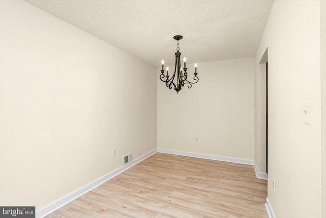 49 Joyner Ct, Lawrence, NJ 08648 - empty room with a chandelier, light wood-style floors, and a textured ceiling
