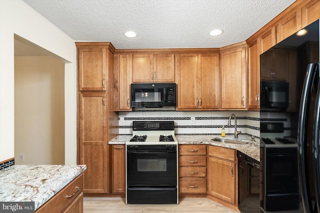 49 Joyner Ct, Lawrence, NJ 08648 - kitchen featuring black appliances, brown cabinets, light wood finished floors, light stone countertops, and a textured ceiling