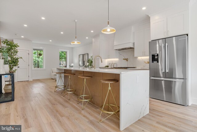 4308 4th St NW, Washington, DC 20011 - kitchen with appliances with stainless steel finishes, custom exhaust hood, white cabinets, light wood finished floors, and recessed lighting