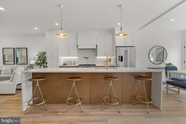 4308 4th St NW, Washington, DC 20011 - kitchen with stainless steel refrigerator with ice dispenser, white cabinets, light countertops, a large island with sink, and recessed lighting