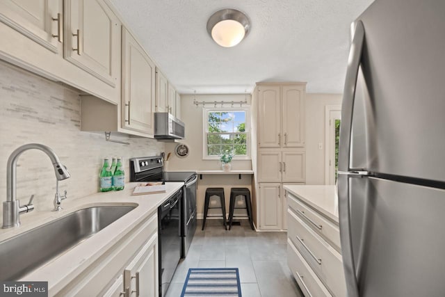 7012 Vantage Dr, Alexandria, VA 22306 - kitchen featuring stainless steel appliances, light tile patterned flooring, light countertops, tasteful backsplash, and a textured ceiling