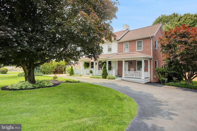 8029 Molly Pitcher Hwy, Shippensburg, PA 17257 - view of front of home with a porch, brick siding, a chimney, a front lawn, and driveway