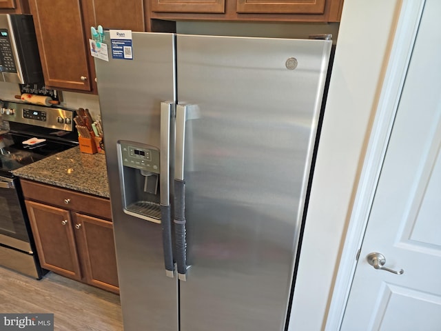 18316 Reaper Hill Ct, Triangle, VA 22172 - kitchen featuring appliances with stainless steel finishes, light wood-type flooring, and dark stone counters