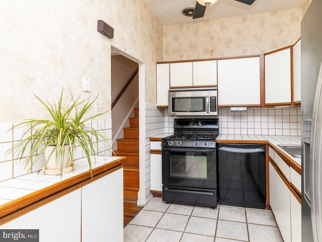 2868 Senak Rd, Abington, PA 19001 - kitchen featuring black appliances, tile countertops, white cabinets, and decorative backsplash