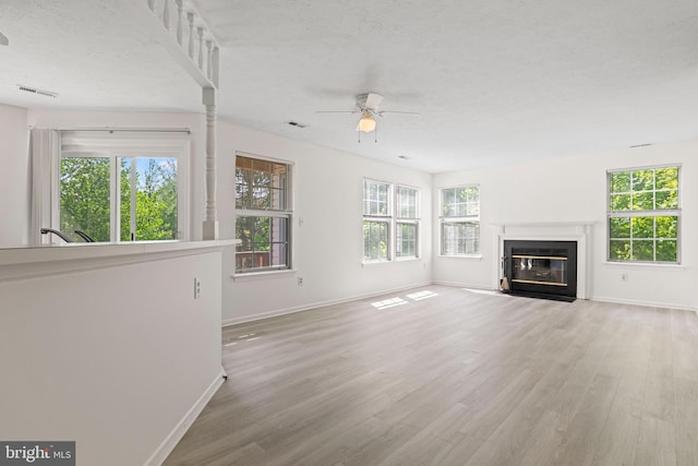 31 Beagle Run Unit 88, Nottingham, MD 21236 - unfurnished living room featuring a ceiling fan, wood finished floors, a fireplace with flush hearth, and a textured ceiling