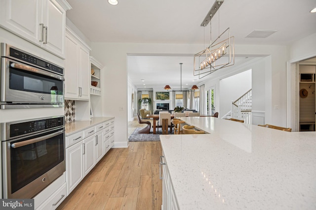 41550 Hepatica Ct, Ashburn, VA 20148 - kitchen featuring recessed lighting, light stone counters, white cabinetry, light wood-style floors, and decorative light fixtures