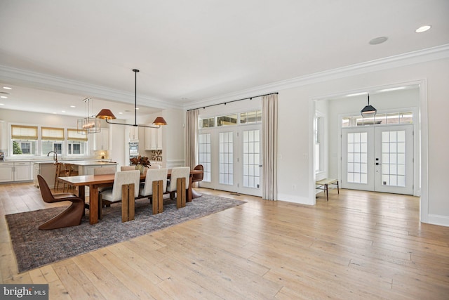 41550 Hepatica Ct, Ashburn, VA 20148 - dining room featuring french doors, light wood finished floors, crown molding, a chandelier, and recessed lighting
