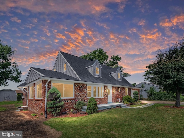 1607 W Furnace Branch Rd, Glen Burnie, MD 21061 - new england style home featuring brick siding, a lawn, a shed, covered porch, and roof with shingles
