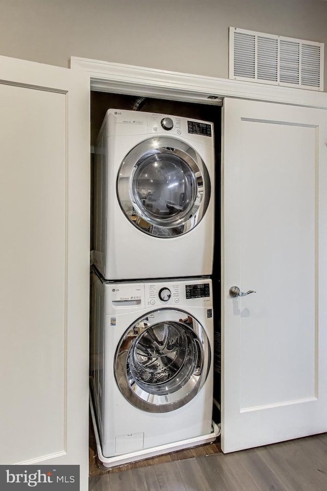 625 Park Rd NW Unit 206, Washington, DC 20010 - laundry room with stacked washing machine and dryer and wood finished floors