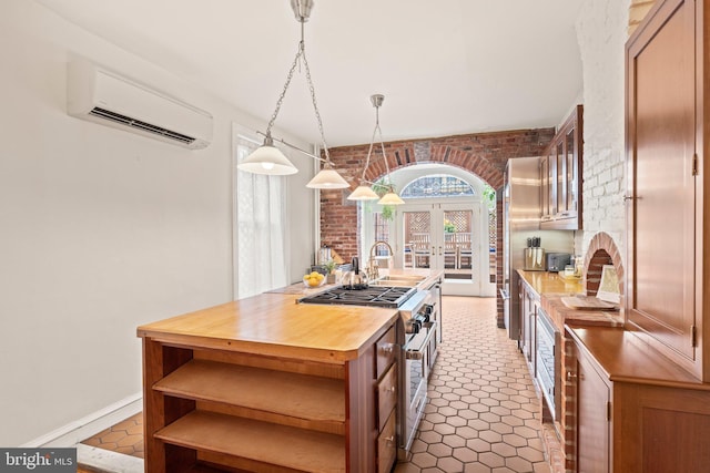 2116 Green St, Philadelphia, PA 19130 - kitchen with high end stainless steel range, a wall mounted AC, wood counters, french doors, and brick wall