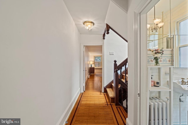 2116 Green St, Philadelphia, PA 19130 - corridor featuring radiator, light wood-style flooring, a chandelier, and stairway