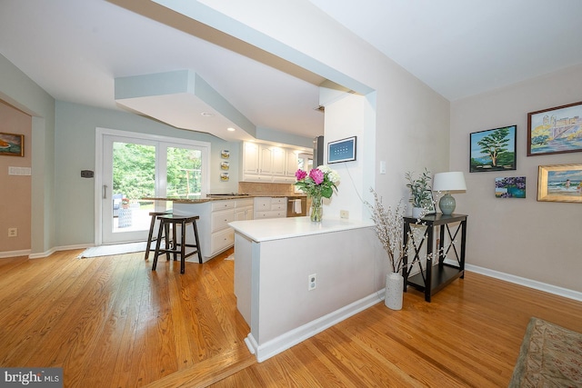 840 Old State Rd, Berwyn, PA 19312 - kitchen featuring light wood-style floors, a peninsula, white cabinetry, and light countertops
