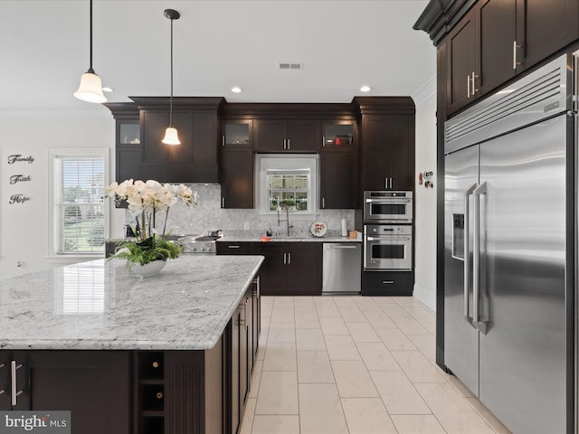 11509 Asbury Ridge Ct, Nokesville, VA 20181 - kitchen with appliances with stainless steel finishes, crown molding, decorative backsplash, light marble finish flooring, and decorative light fixtures