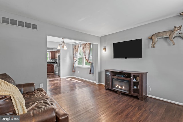 701 Hunters Run, Perkasie, PA 18944 - living room with dark wood finished floors, a chandelier, and a glass covered fireplace