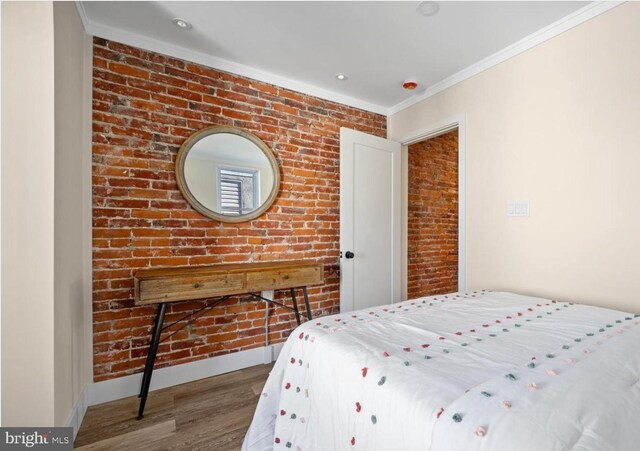 5717 Larchwood Ave, Philadelphia, PA 19143 - bedroom with wood finished floors, crown molding, and brick wall
