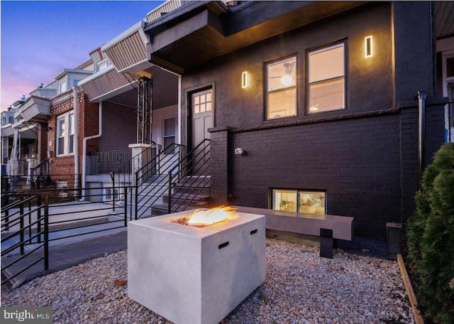 5717 Larchwood Ave, Philadelphia, PA 19143 - view of property exterior with an outdoor fire pit, brick siding, and stucco siding