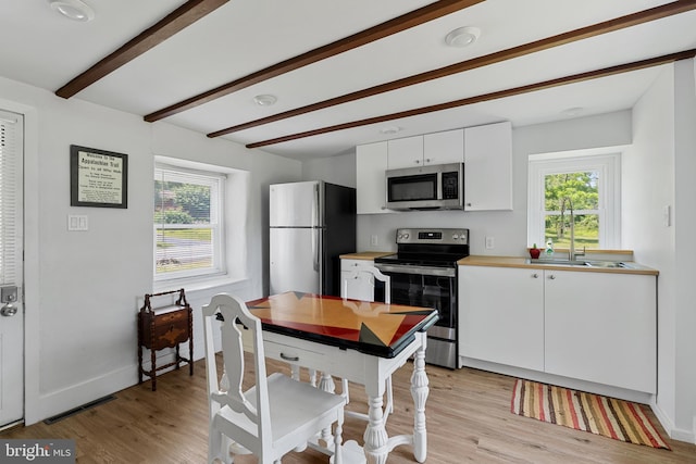 2397 Hill Rd, Perkiomenville, PA 18074 - kitchen featuring stainless steel appliances, light wood finished floors, beam ceiling, white cabinetry, and light countertops