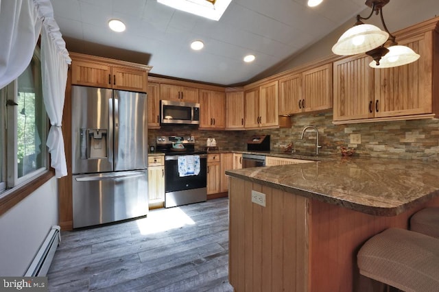 99 Old Main Shore Rd, Barnegat, NJ 08005 - kitchen featuring appliances with stainless steel finishes, a baseboard heating unit, a peninsula, wood finished floors, and a kitchen breakfast bar