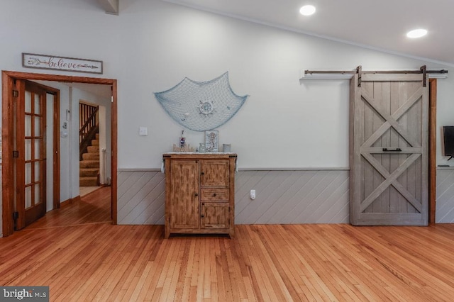 99 Old Main Shore Rd, Barnegat, NJ 08005 - corridor with light wood-type flooring, a wainscoted wall, a barn door, stairway, and wooden walls
